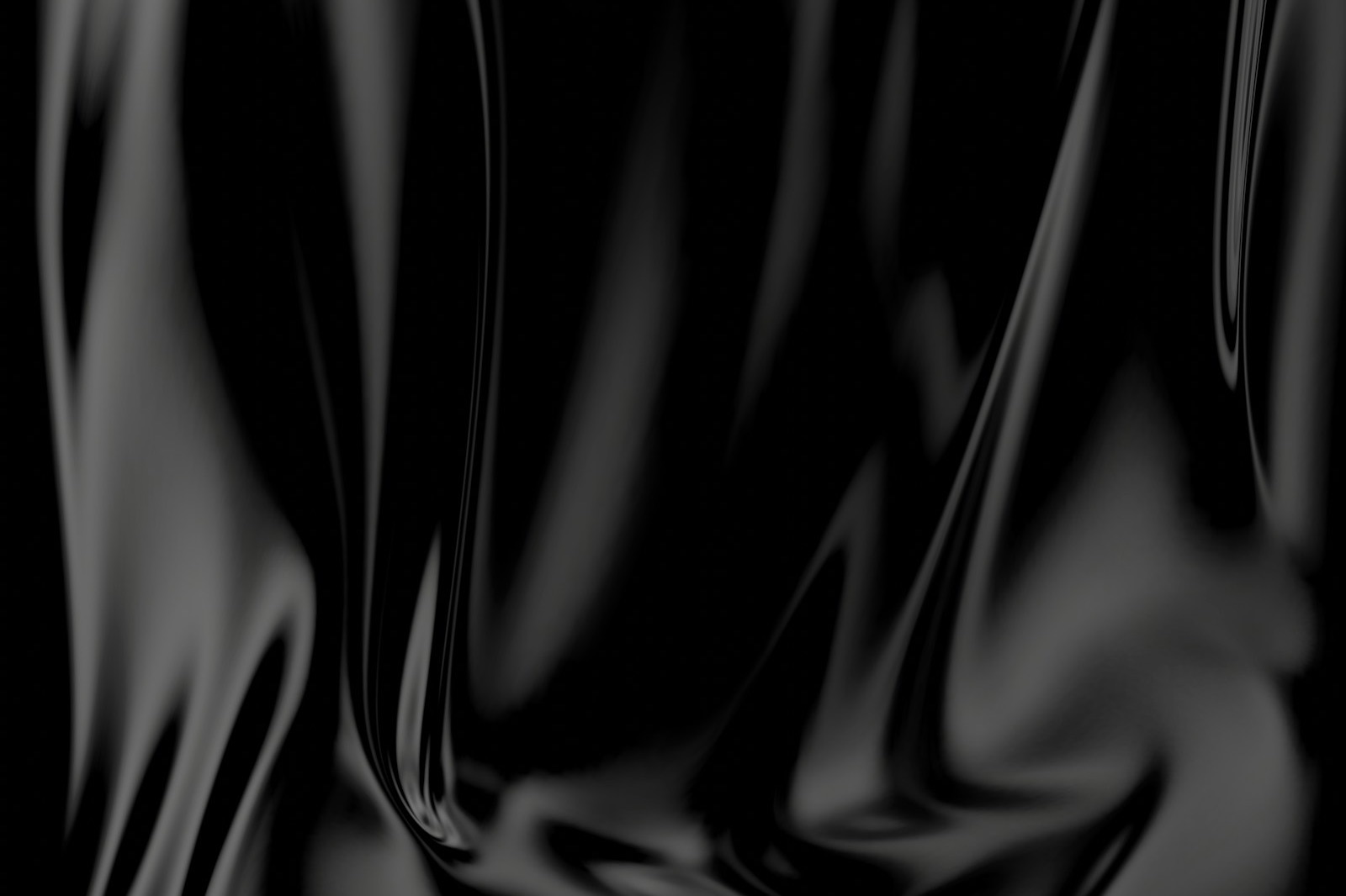 Folds of glossy black material catching the light against a dark background